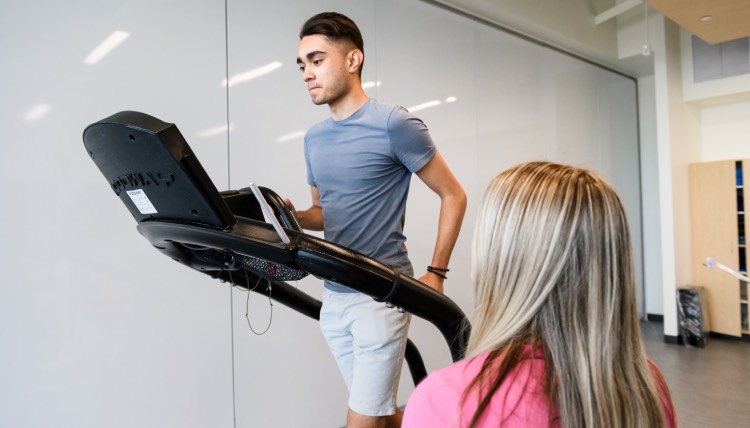 Student running on a treadmill in lab
