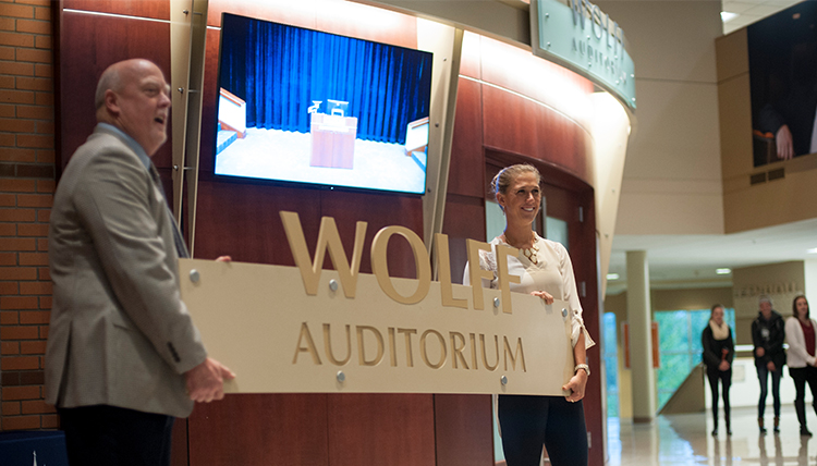 two people hold up sign reading Wolff Auditorium for Gonzaga's School of Business