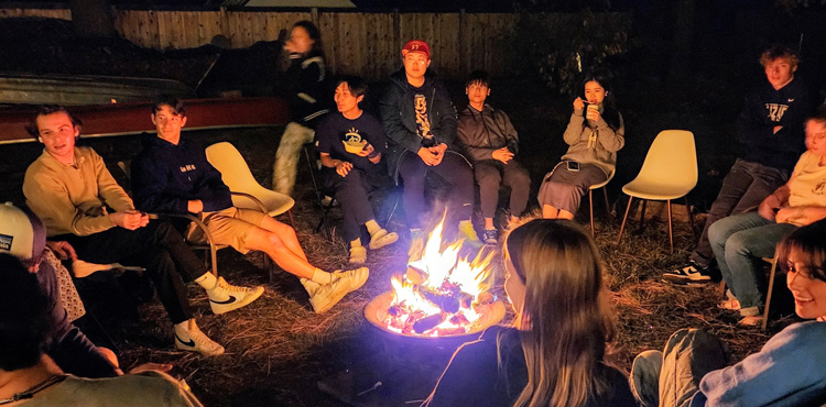 International students around a campfire in Professor Eliason's backyard.