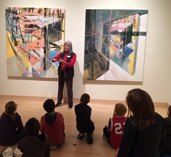 Jundt Art Museum Volunteer Docent lectures young students.