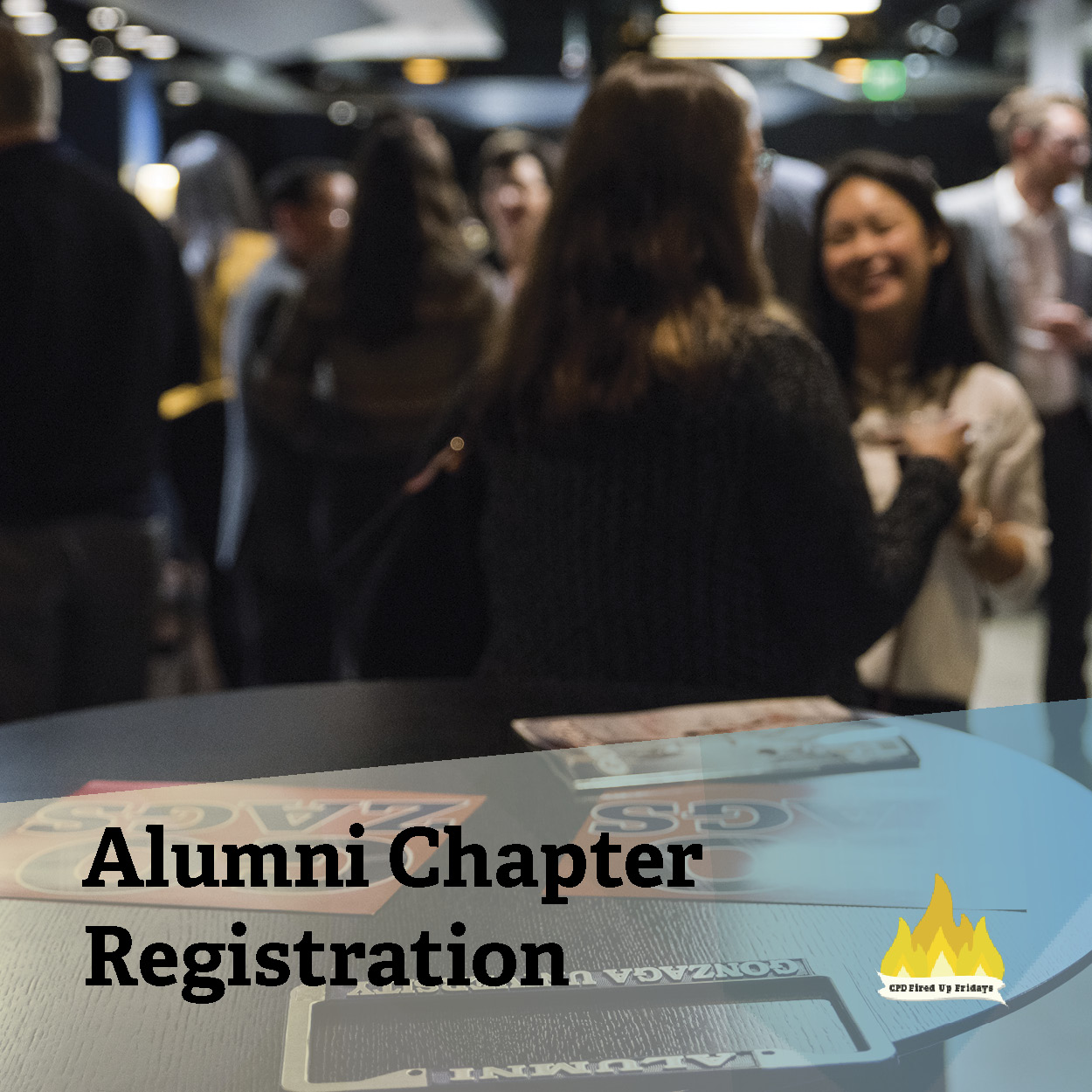 In the foreground, a pair of red hand hand signs reading 'Go Zags!' sit on a black round table. Just out of focus beyond the table, Gonzaga alumni socialize together. Underneath the image reads, 'Alumni Chapter Registration.'