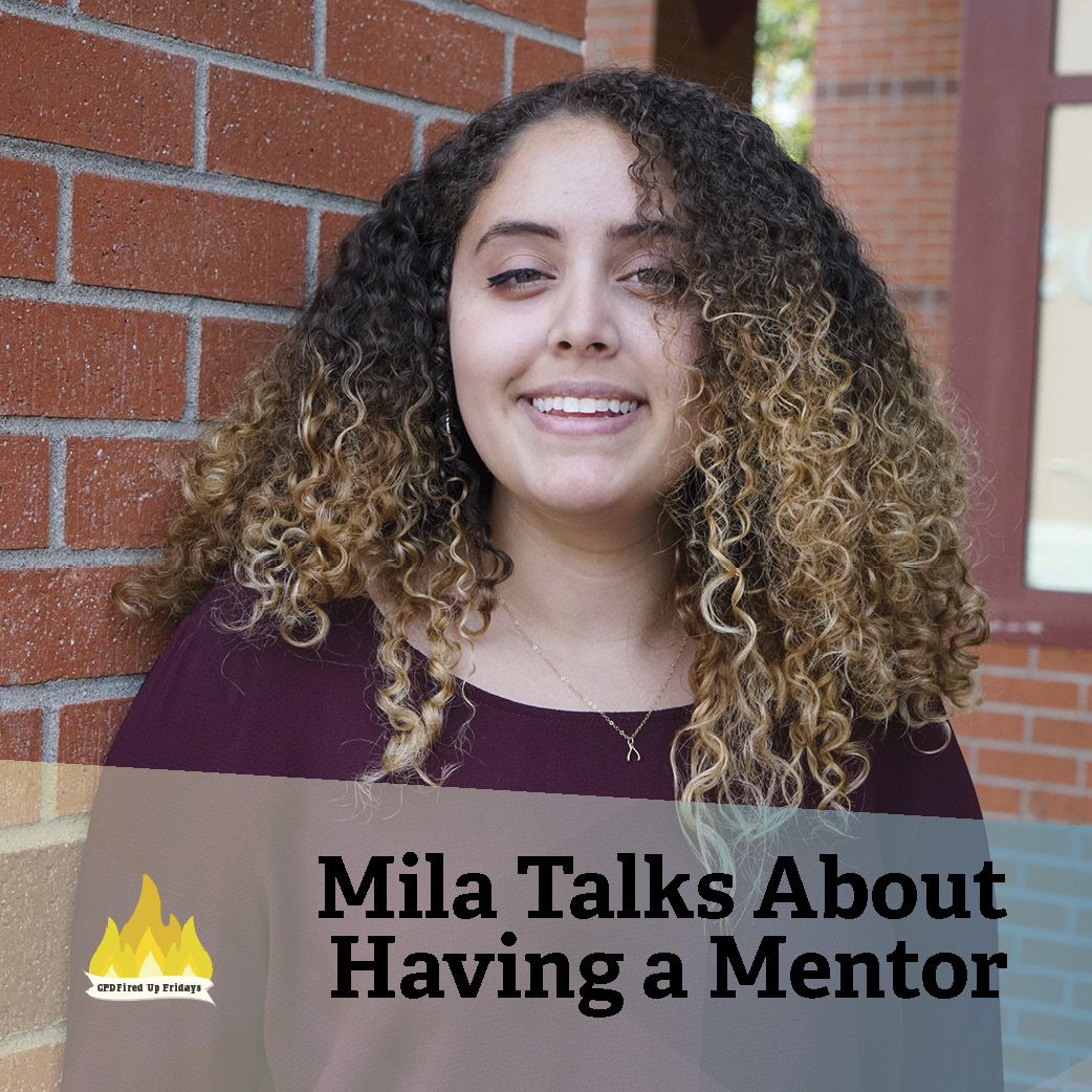 Mila Yoch smiles into the camera, standing in front of a brick wall. Underneath, text reads: 'Mila Talks About Having a Mentor.'