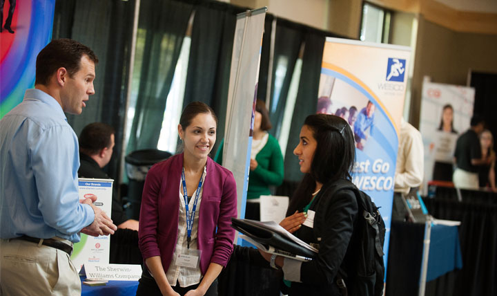 A students speaks with Employers at a Career Fair.