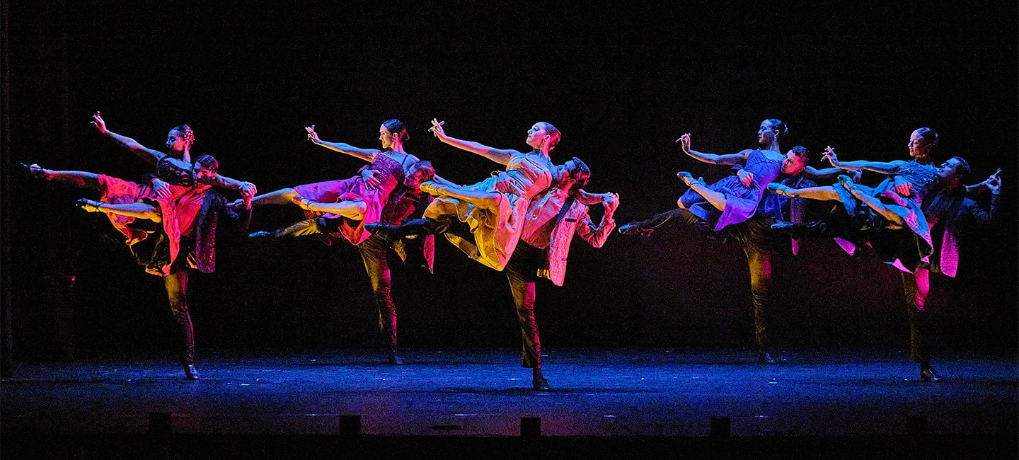 Ballet Hispanico members dancing in unison on stage.