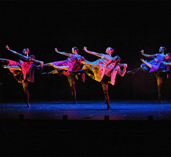 Dancers on stage danving in unison.
