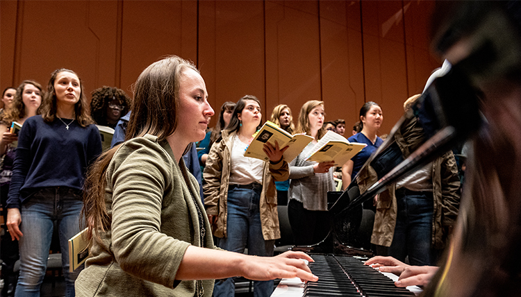 student pianist with choir in background