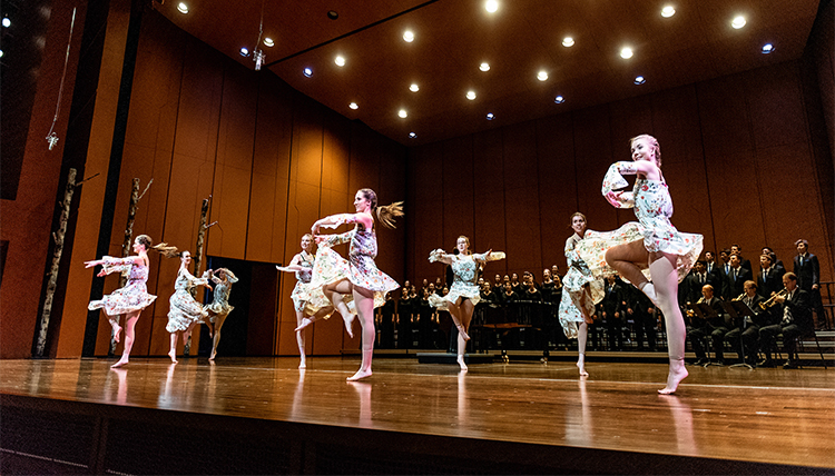 dancers on stage with musicians in the background