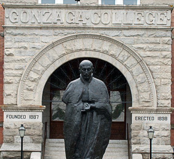 The statue of St. Ignatius stands before the entryway to College Hall