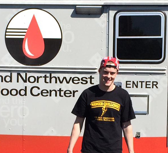 Student standing in front of blood drive bus