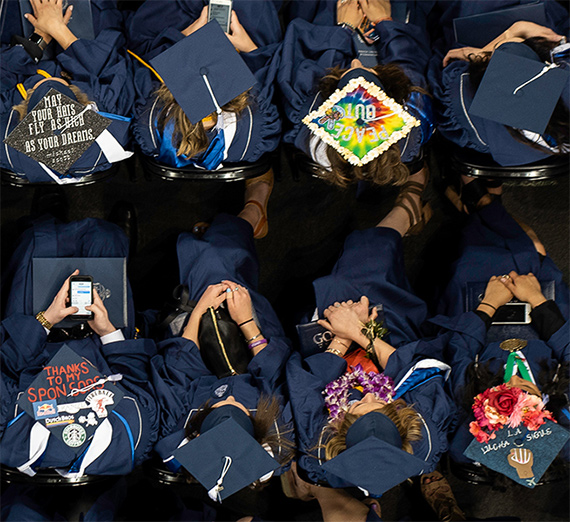 Undergraduate students show the messages written on their mortar boards