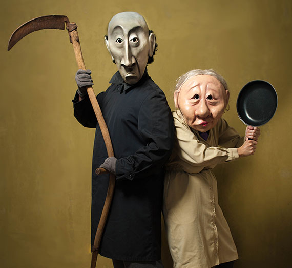 performers with masks dresses as the Grim Reaper and an elderly woman with an iron skillet