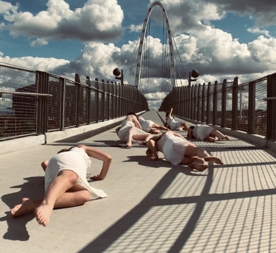 Dancers lay on a bridge while filming a screendance