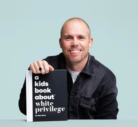 sand pictured holding authored book titled a kids book about white privilege 