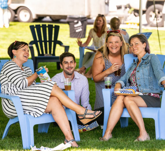 Employees smile for photo while enjoying the faculty appreciation BBQ