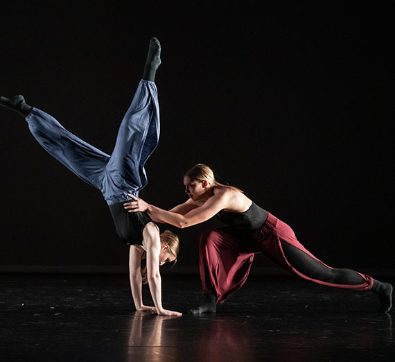 Two dancers pose on stage.