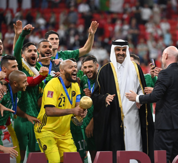 Soccer/Football team celebrating victory. Goalie holding a trophy.