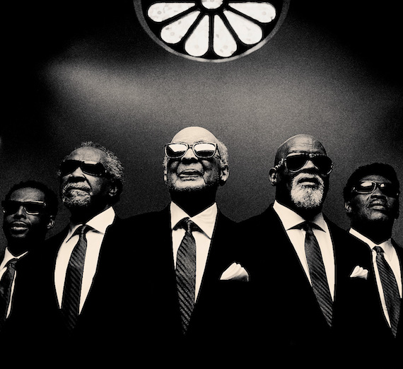Black and white photo of five African American men in suits with sunglasses