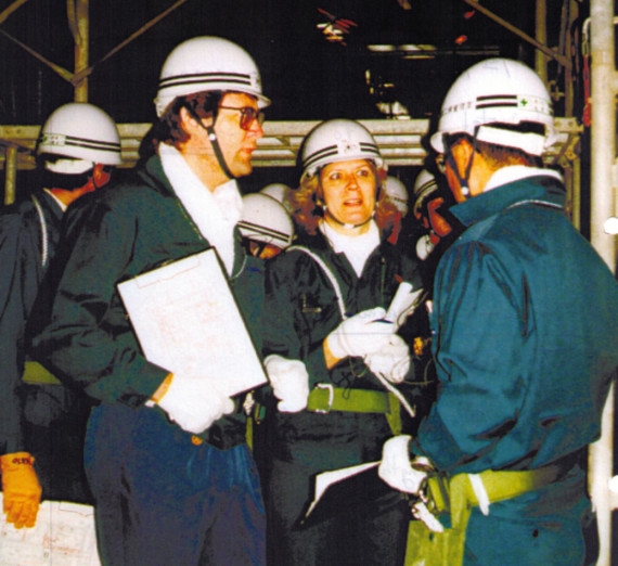 Shirley Johnson at a job site wearing a hard hat, gloves and safety belt.