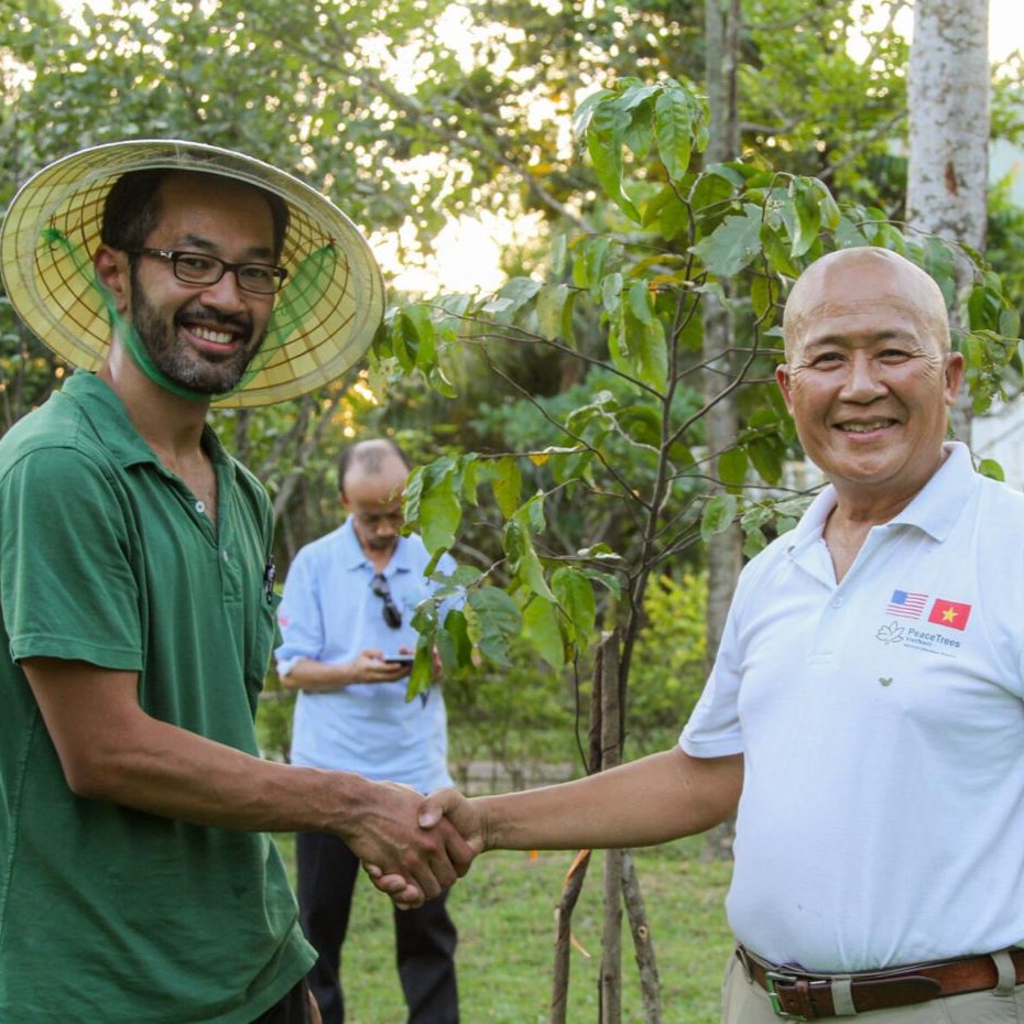 Dara Yin, a diplomat with the United States Department of State, shakes hands with a local representative after planting a peace tree in Quảng Trị, Vietnam