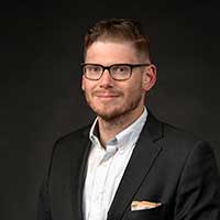 jim poses with a black background