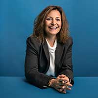 president passerini poses in front of a blue background