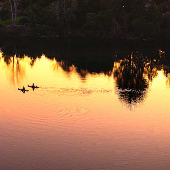 kayakers on spokane river at sunset
