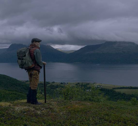 A man looking out at the northern Norway coast on a beautiful stormy day 