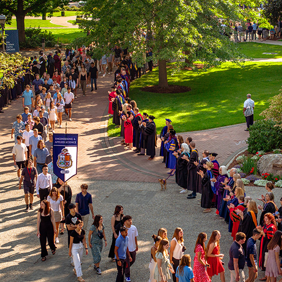 A procession of incoming freshmen walk to Academic Convoctation.