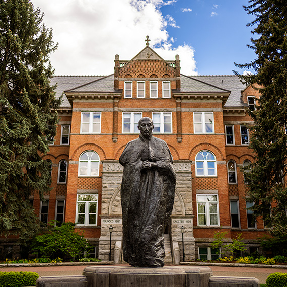 A statue of St. Ignatius stands in front of Gonzaga's College Hall.