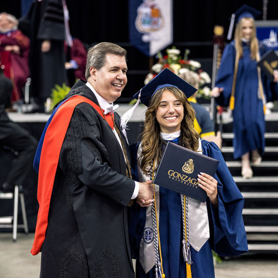 President Thayne McCulloh congratulates a female graduate at the 2023 Commencement ceremony.