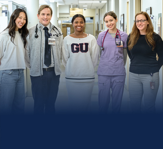 UW-GU Health Partnership students posing, smiling in a hospital hallway.