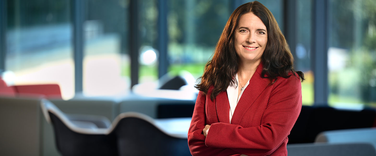Woman in a red blazer poses in the Bollier Center
