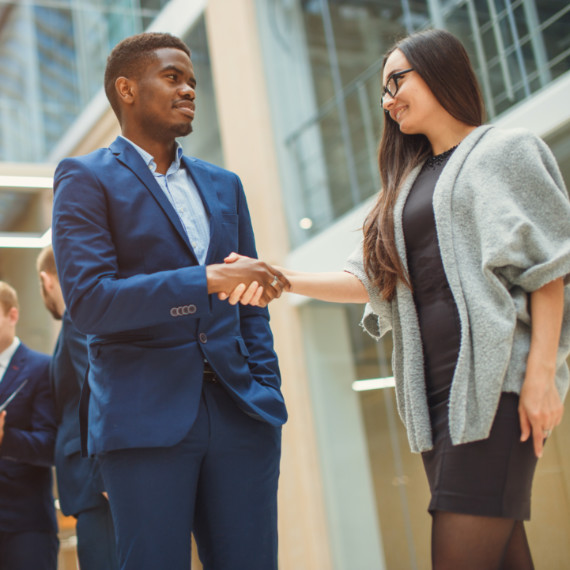 Man and woman shake hands at a networking event