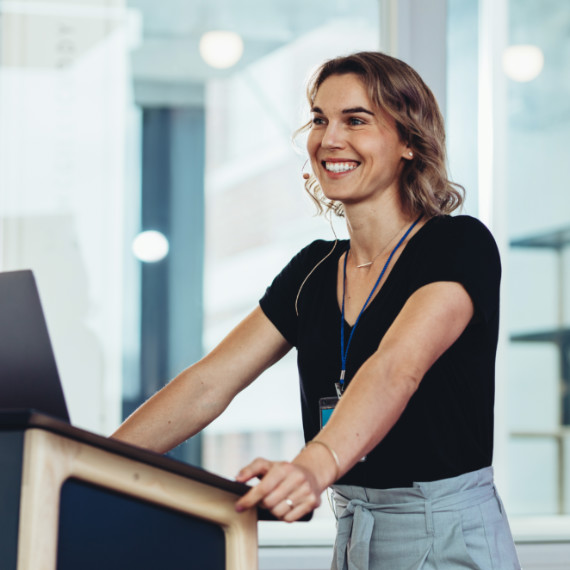 A woman standing at a podium smiling