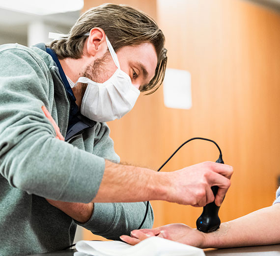 A nurse uses a Butterfly handheld ultrasound device