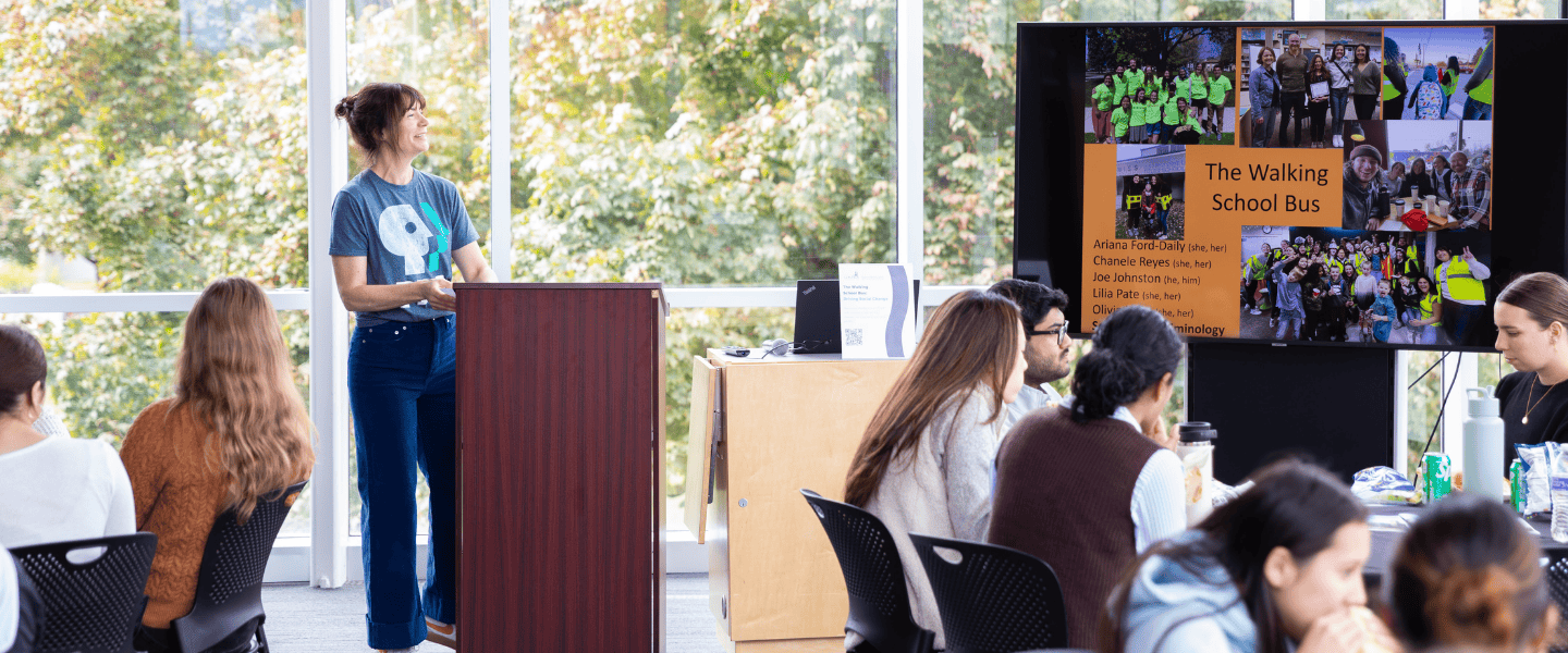 woman talking at the front of a classroom to other people