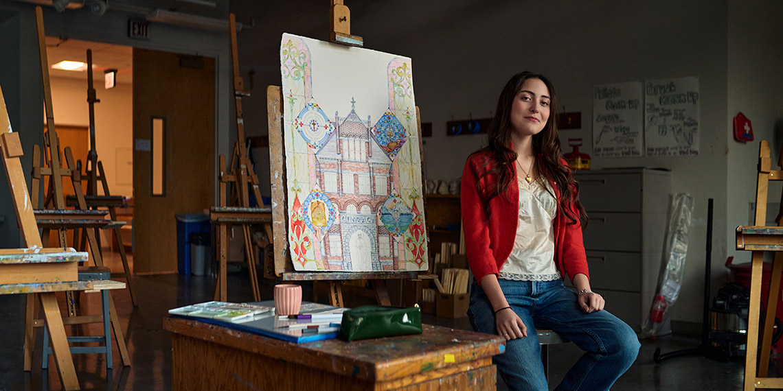Sophie standing in front of painting in an art room
