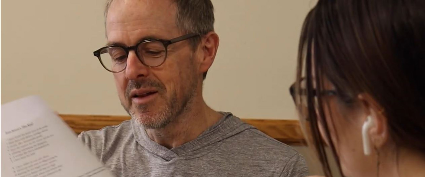 Dr. Tod Marshall talking about a paper with a student. 