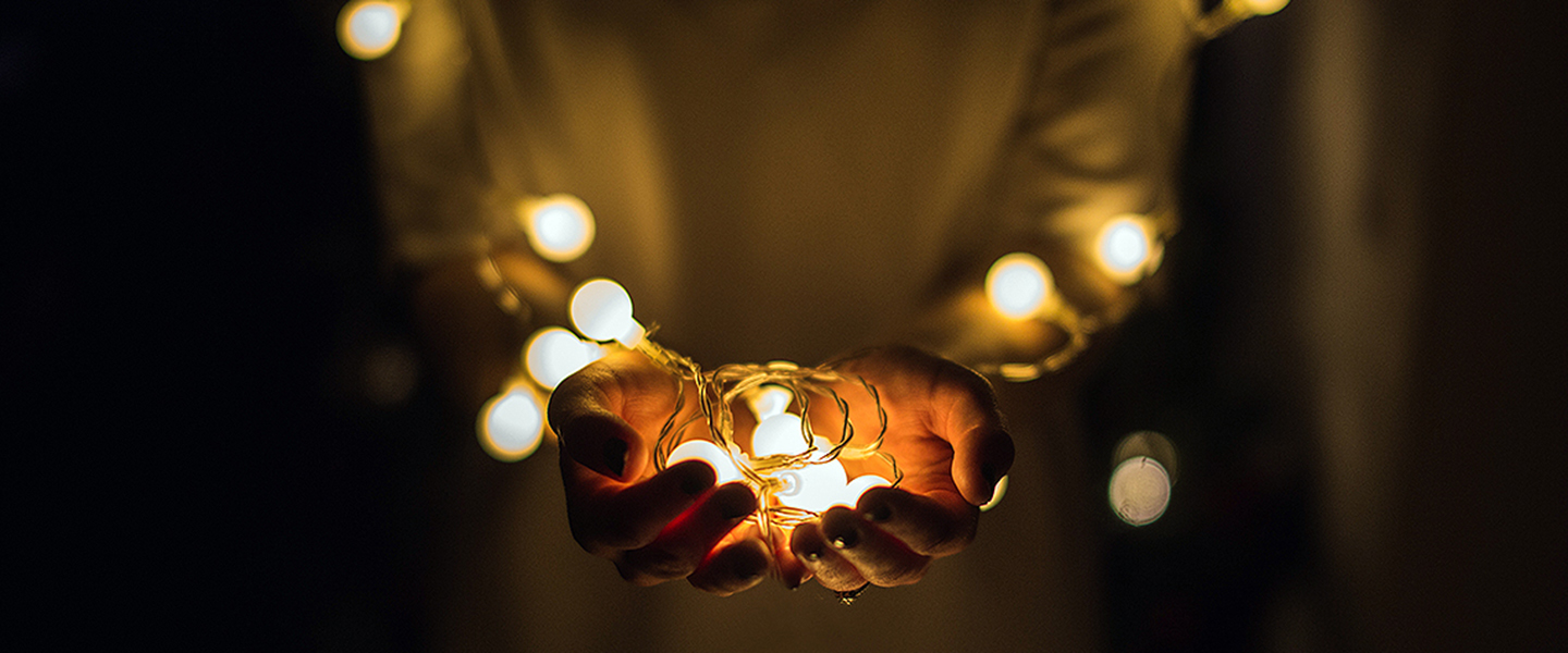 Decorative image, hands holding small lightbulbs