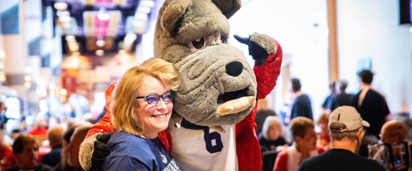 Basketball pregame event attendee poses with Spike, the Gonzaga mascot