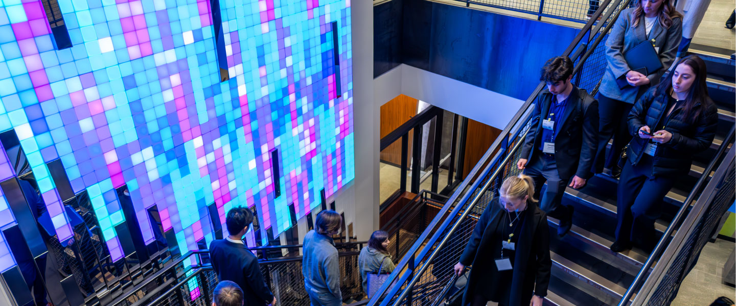 Gonzaga students in business attire walk down staircase in a technology company office