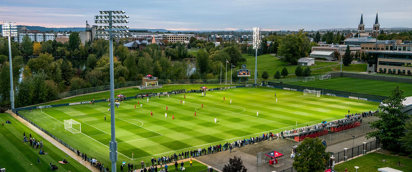 Aerial photo of Luger field at dusk with St. Aloysius church in the background during a soccer game