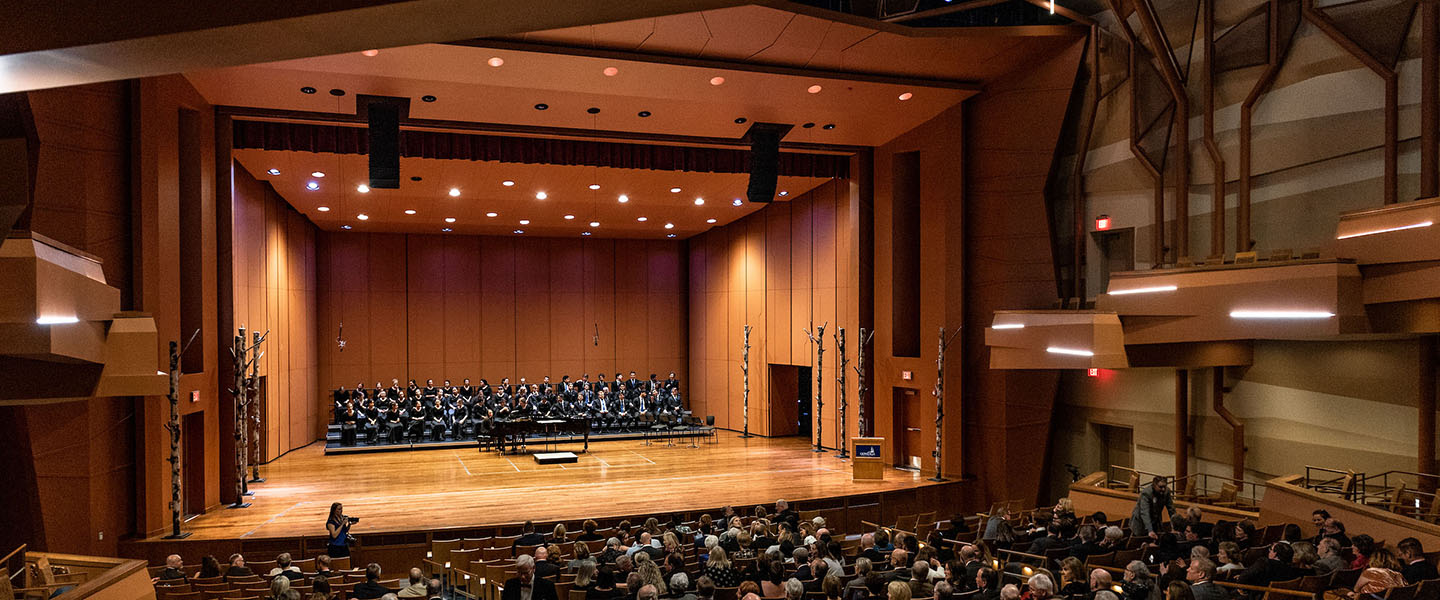 GU Concert Choir performing on the stage of the Coughlin Theater