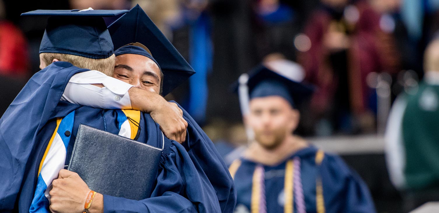 Two students hugging during Commencement ceremony