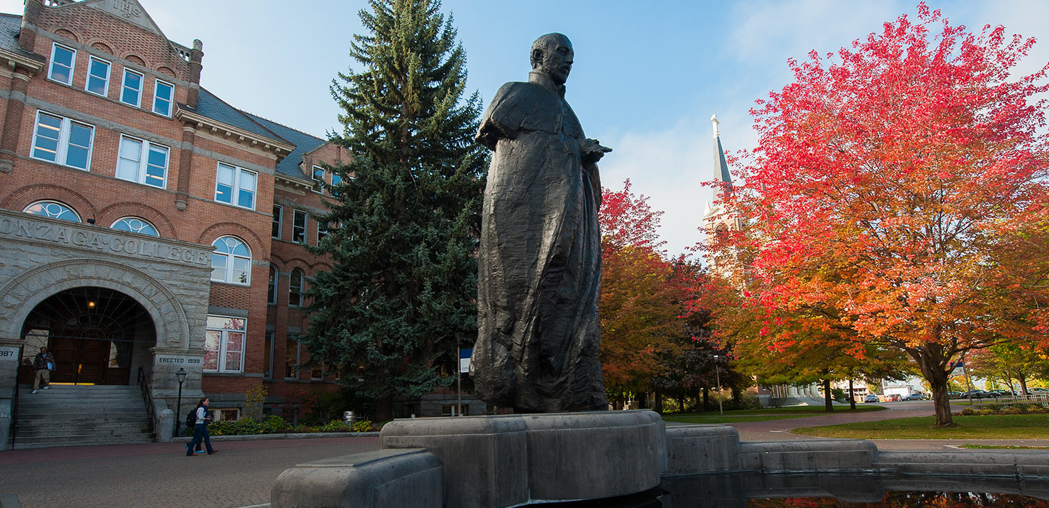 A statue of St. Ignatius of Loyola in front of Gonzaga's College Hall