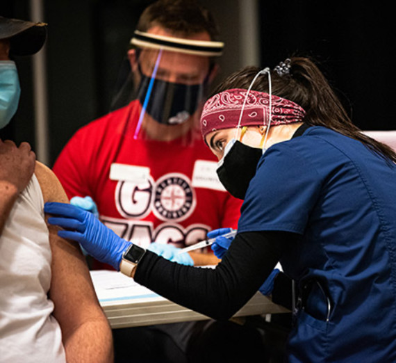 A Gonzaga University nursing student gives a patient a vaccine during the COVID-19 pandemic