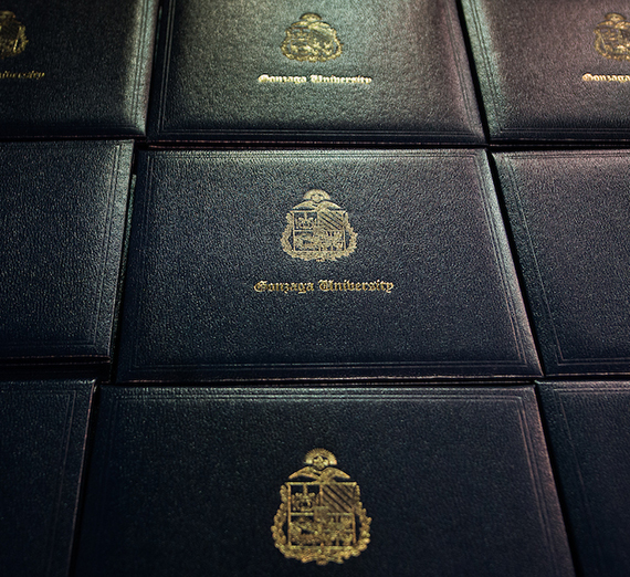 Certificates of graduation lined up on a table at the Graduate Commencement.