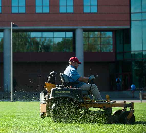 A member of Plant Services mows the Foley Quad on a riding mower