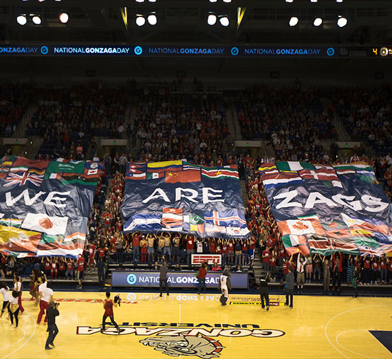 A banner that reads We Are Gonzaga is held by students at halftime during a basketball game.