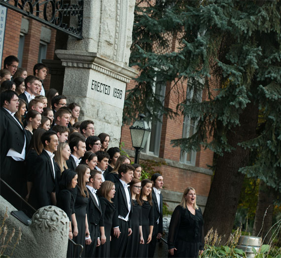 choir singing on steps of college hall 